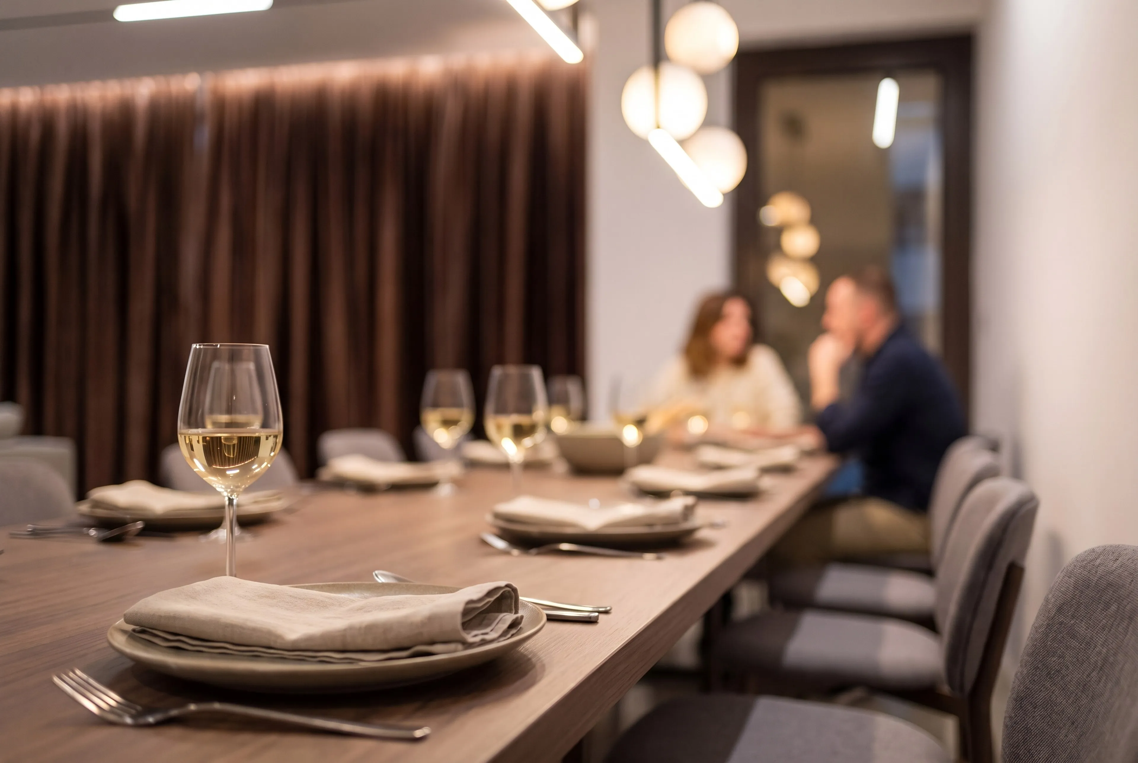 Dining room: a set table, globe pendant and a couple at dinner