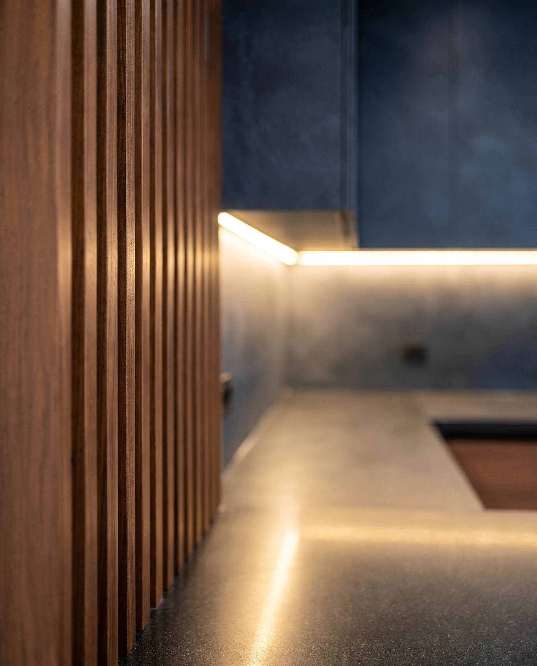 Kitchen: walnut slatted partition and under-cabinet lighting