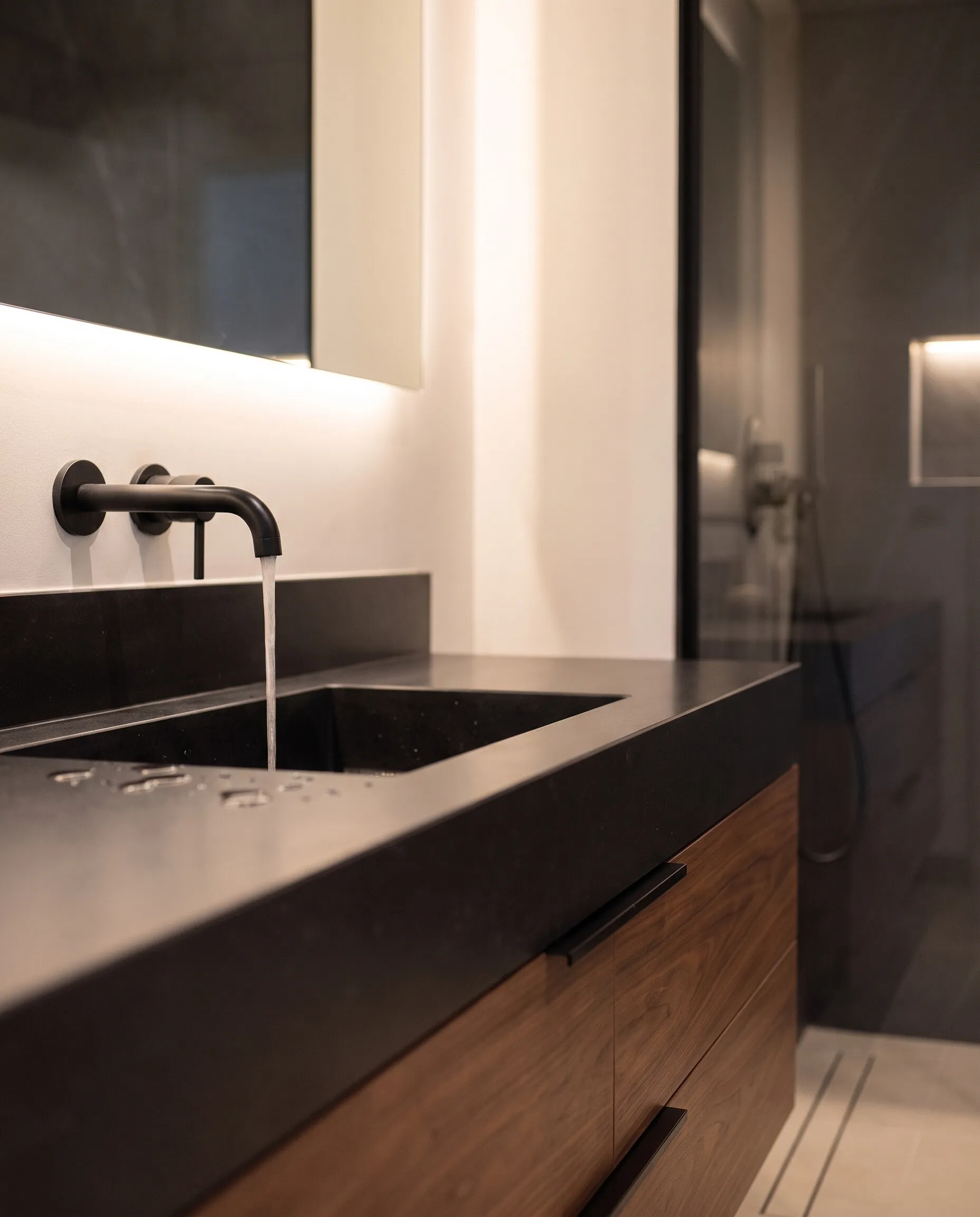 Bathroom: black tap and a dark stone basin